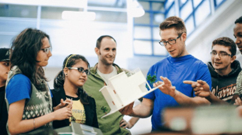 A group of students looking at an architectural model