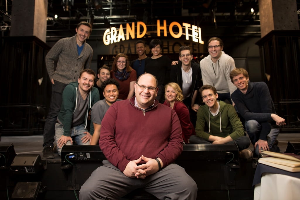 Michael Rubinoff and students in front of a Grand Hotel sign