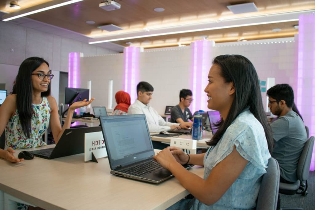 Two people interacting seated at a table at Sheridan's EDGE hub