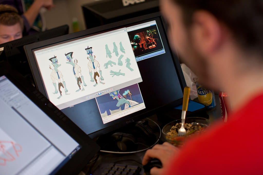 A student is pictured creating an animated character on their computer screen