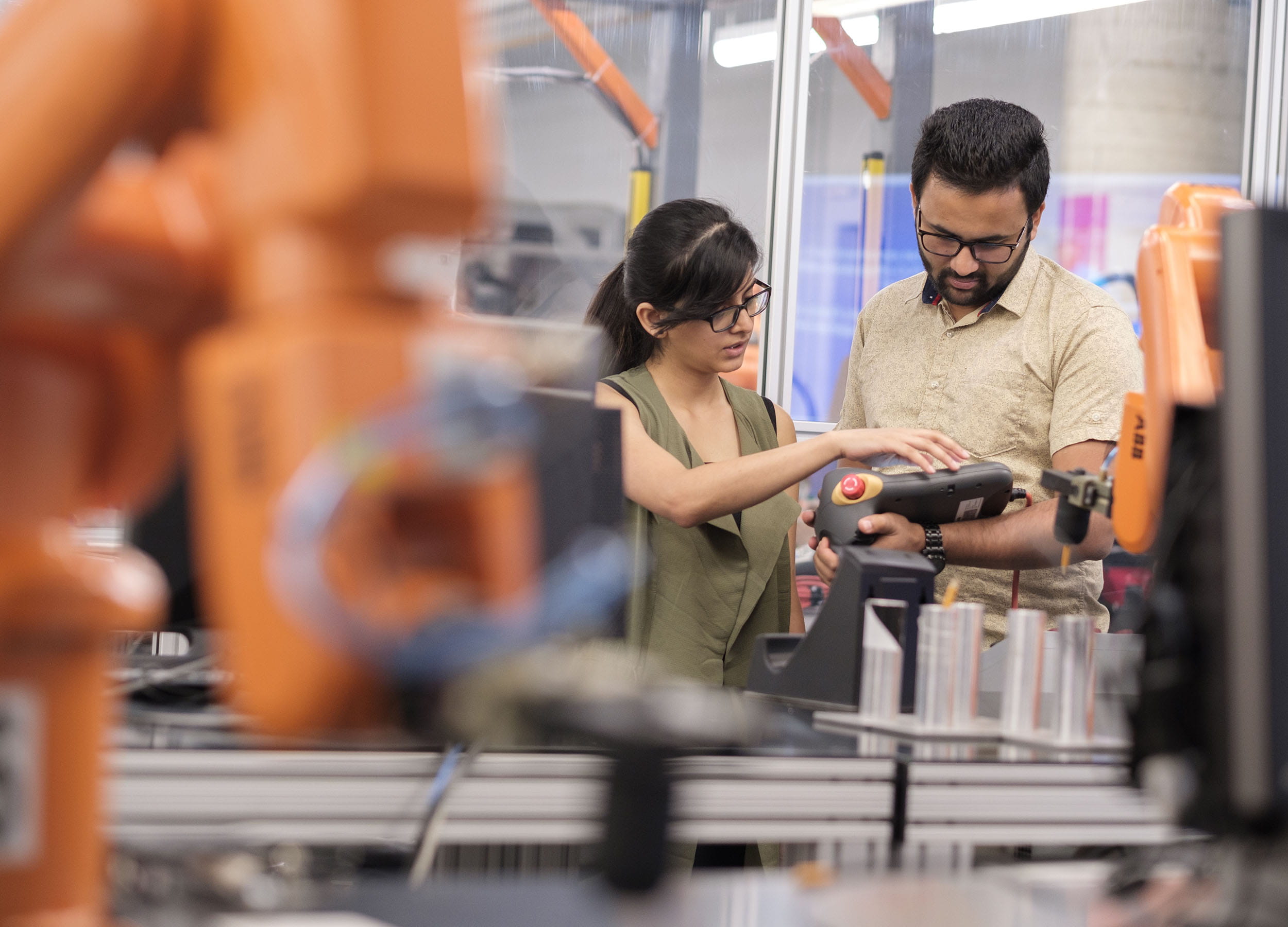 Two students looking at equipment in an engineering lab at Sheridan